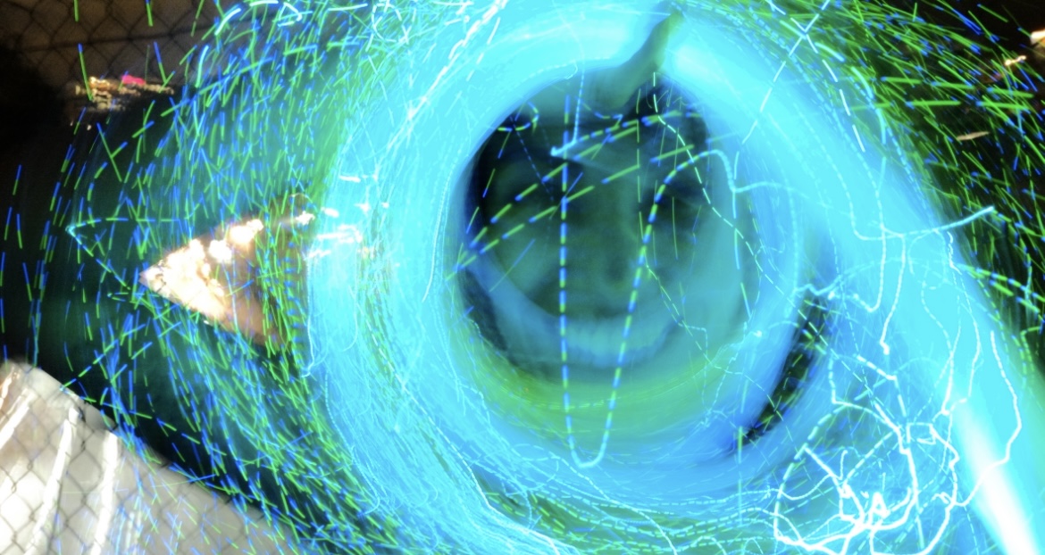 Luna inside a swirling blue and green light portal, smiling through the trails